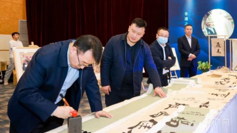 摆着一张长长的桌案,魏宝山挥毫泼墨,在桑皮纸上龙飞凤舞地展现着书法