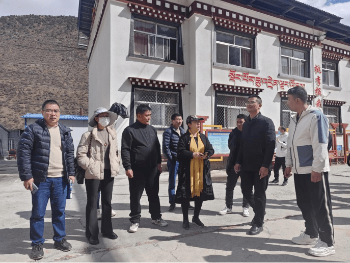 江达县教育局副局长覃子湘(三角中学副校长挂职)的陪同下来到了公布