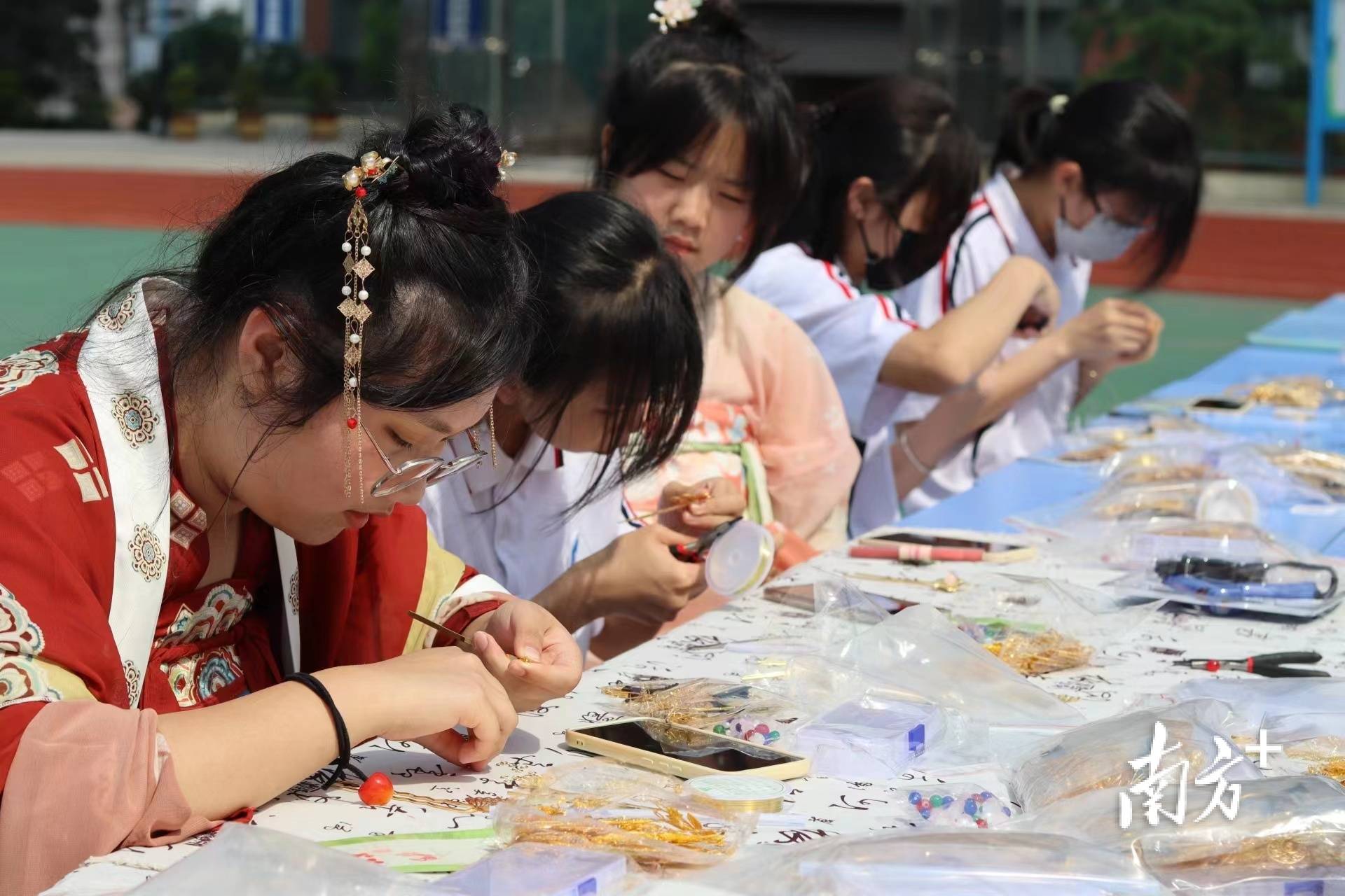 活动现场设有中国传统文化手工diy摊位——发簪制作,手绘团扇,国画