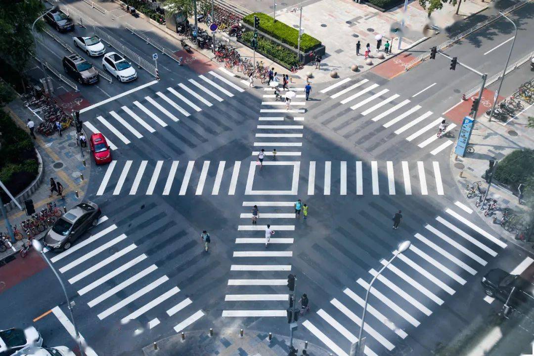 人行道绿灯一亮,十字路口立即"清空",各方向机动车在停止线后,等待行