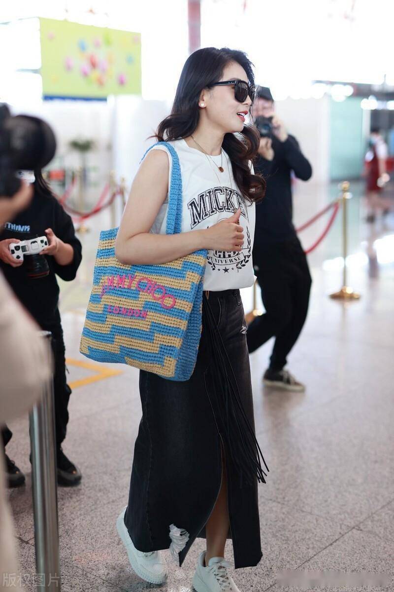 街拍:刘涛波浪长发 钩针包 半身裙 小白鞋随性休闲_北京_机场