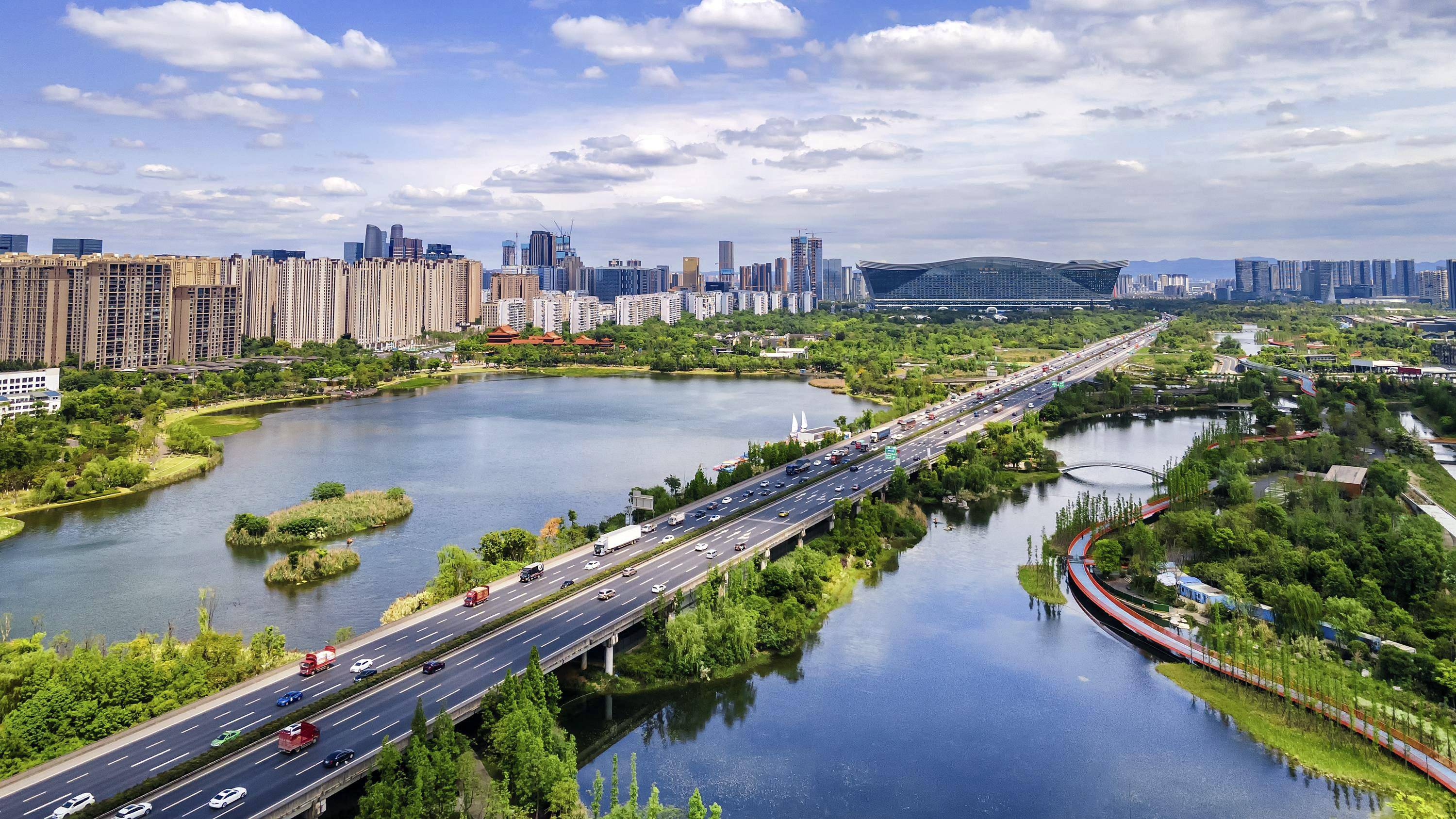 这是2021年4月25日无人机航拍的成都市锦城湖公园和附近的新世纪环球