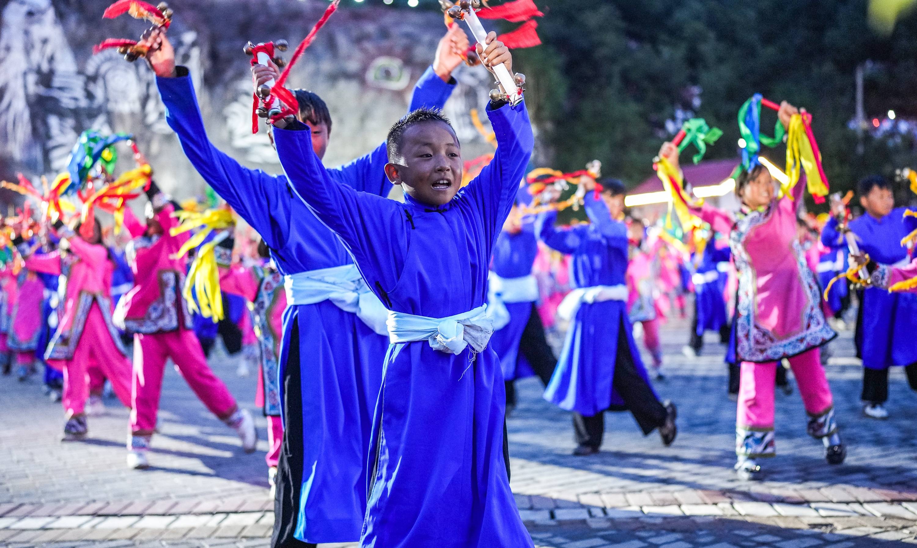 小朋友在威宁彝族回族苗族自治县火把节活动上表演铃铛舞(8月10日摄).