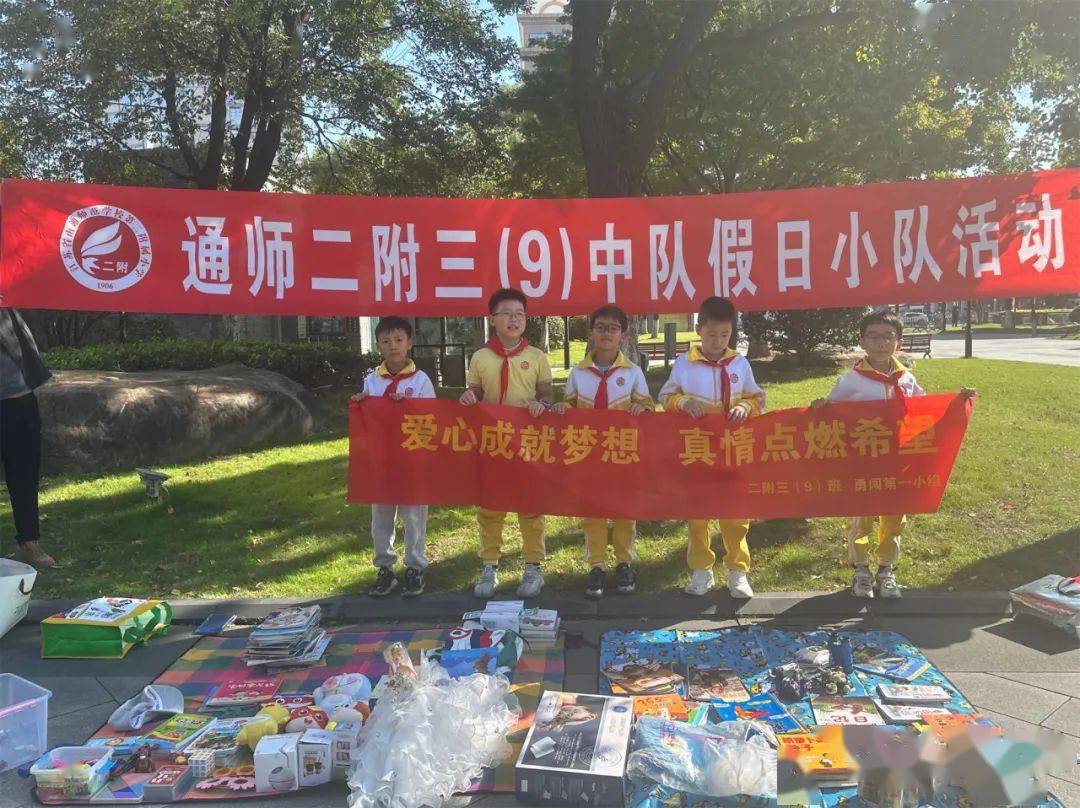 少先队员们拉好爱心义卖的红色横幅,把物品整齐摆放在摊位上.