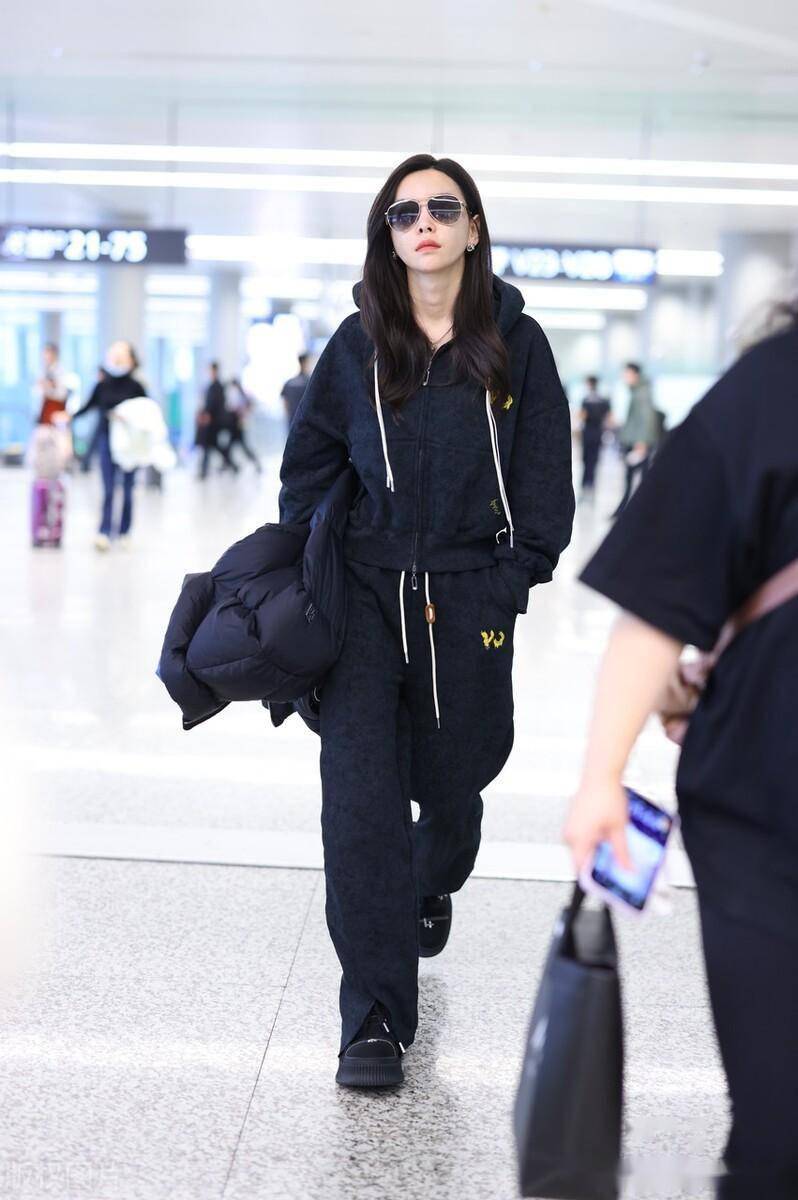2023年11月10日,上海,于文文机场街拍.黑色卫衣套装休闲酷感.