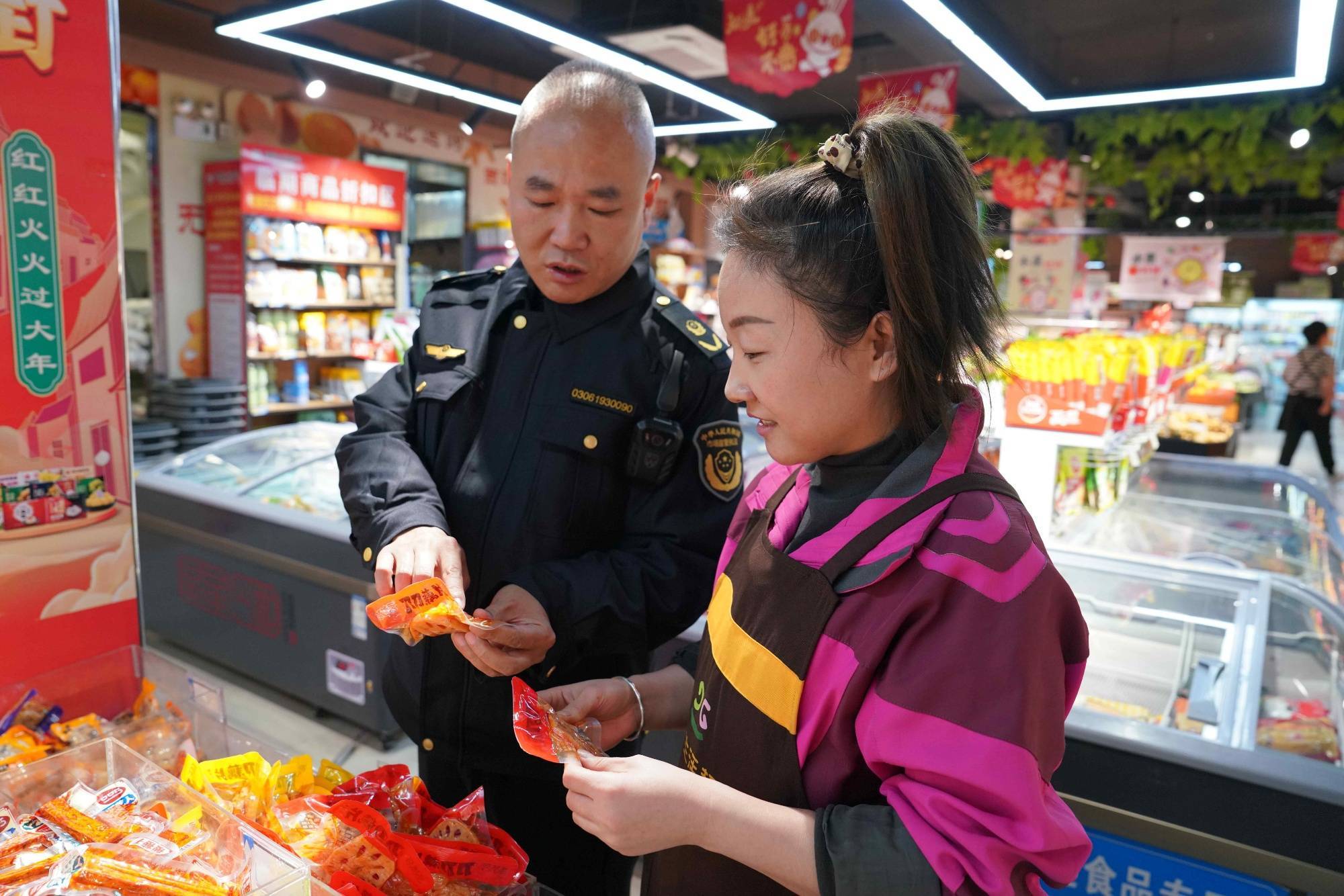 执法人员检查农村超市食品生产日期(杨佳义 摄)