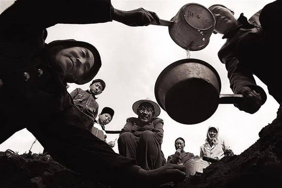 2006年5月6日,渭源县大安乡邱家川村,村民在山眼泉池下舀水,传递给